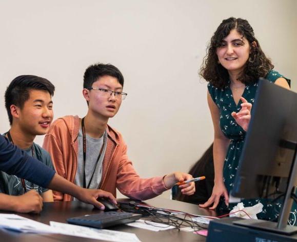 A professor working with three students